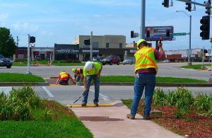 ADA Compliance example: Construction crews installing detectable warnings within curb ramps.
